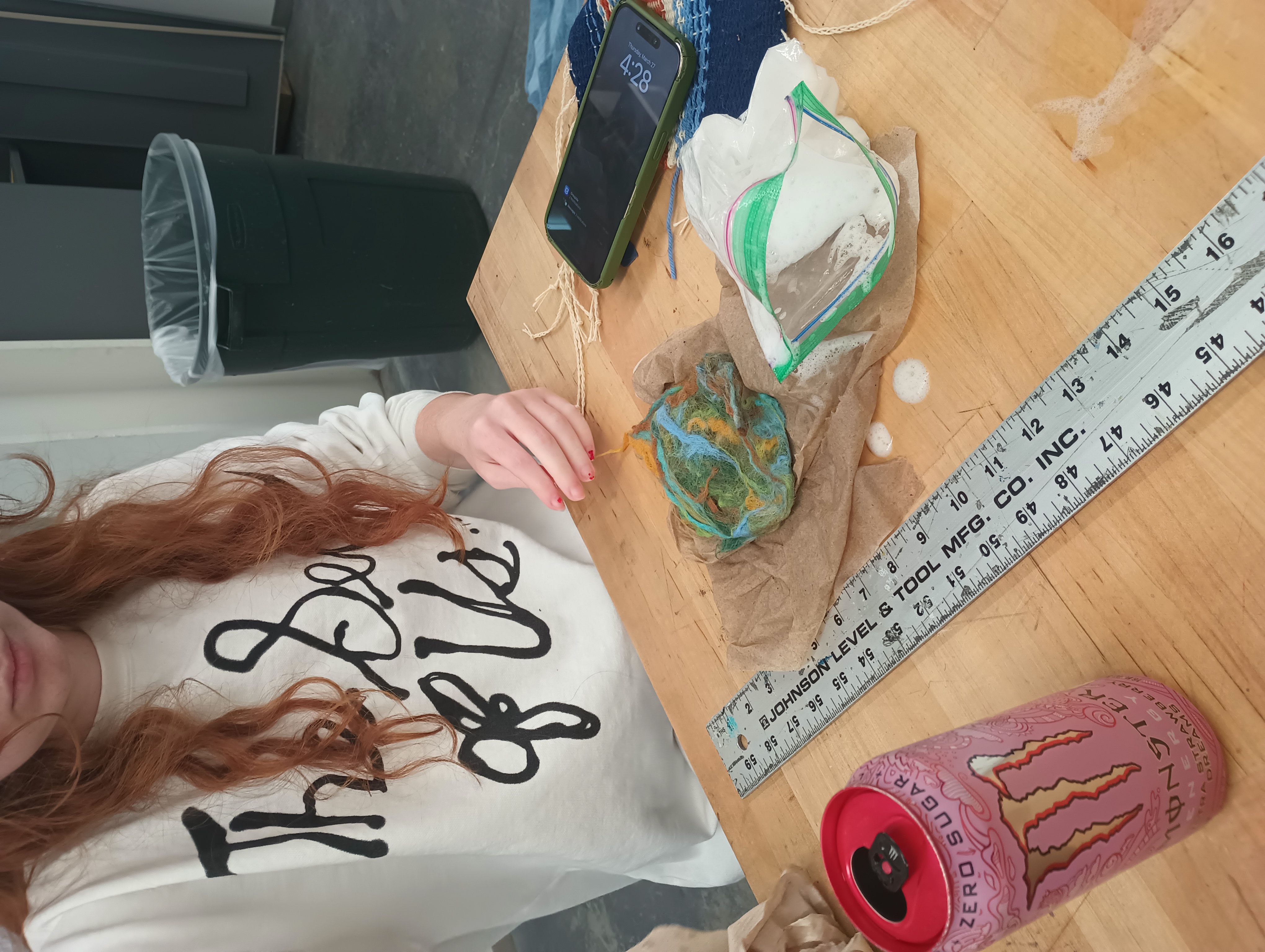 A student prepares a sheet of blue and brown felt on a paper towel.