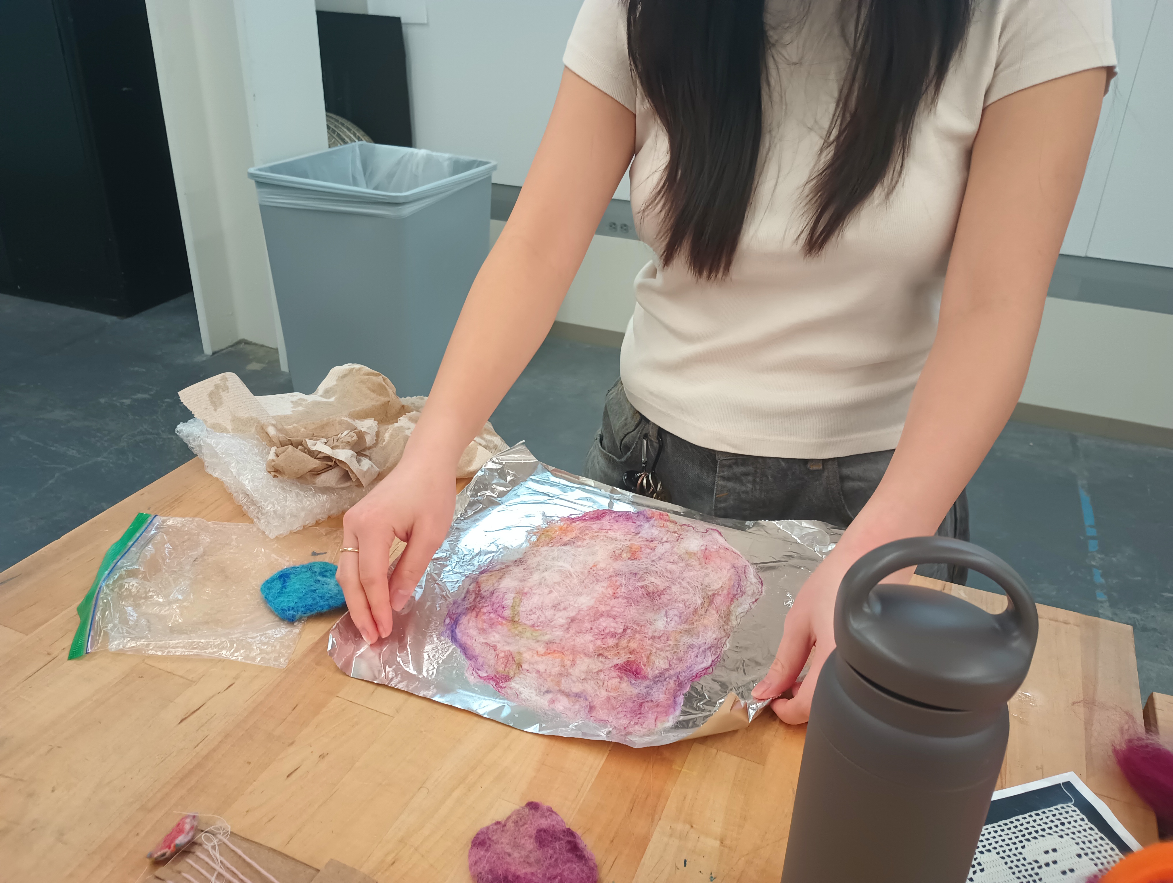 A large piece of variegated pink felt lying on a sheet of tinfoil.