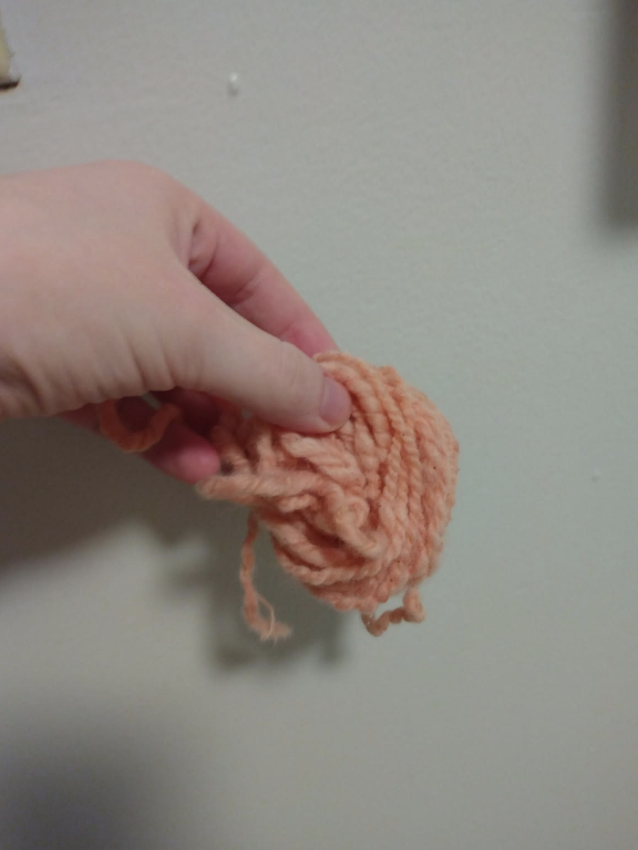 A small ball of yarn dyed pale orange with madder root.