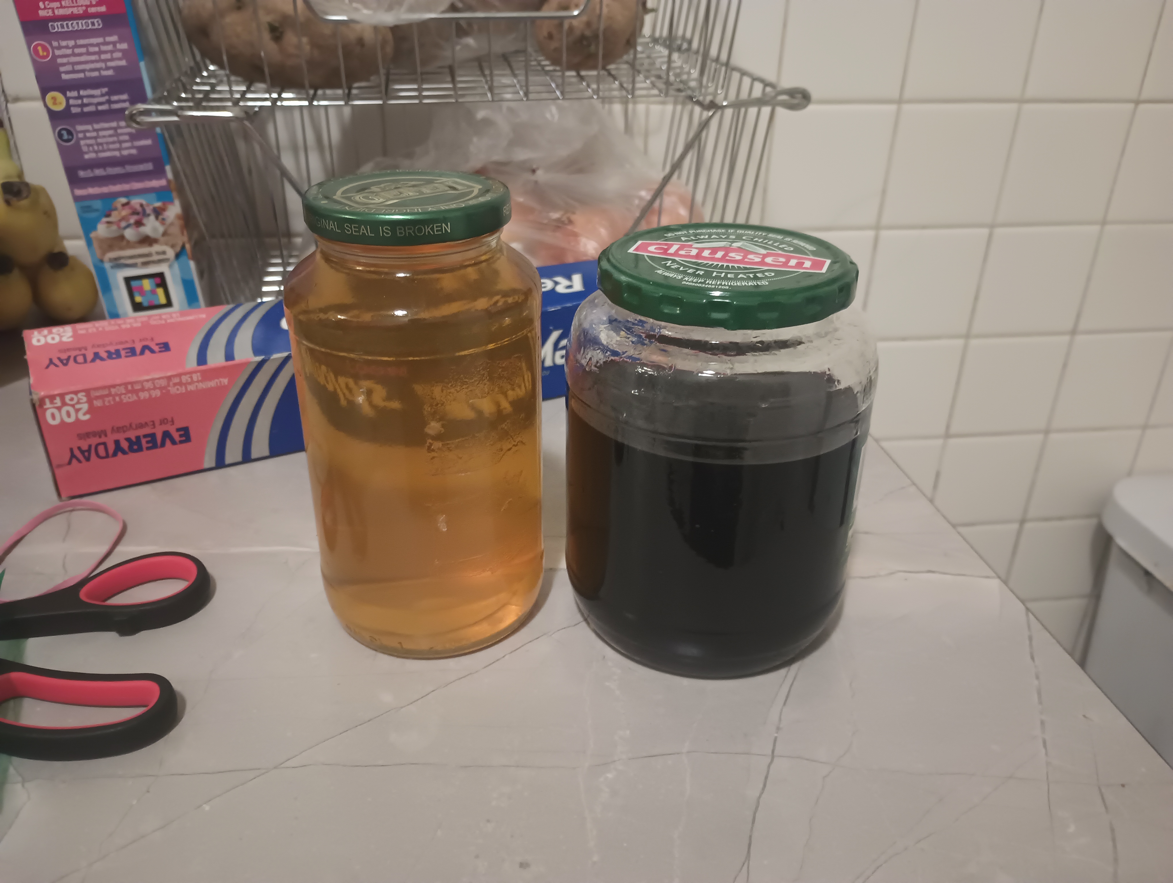 Two jars of dye extract: yellow extract from osage, and black/purple extract from cochineal.